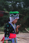 Hmong girl in traditional clothes texting on a mobile phone